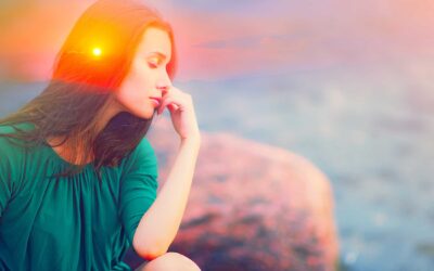 Double exposure picture with silhouette of calm woman overlaid on a scenic sunset with mountains on the horizon