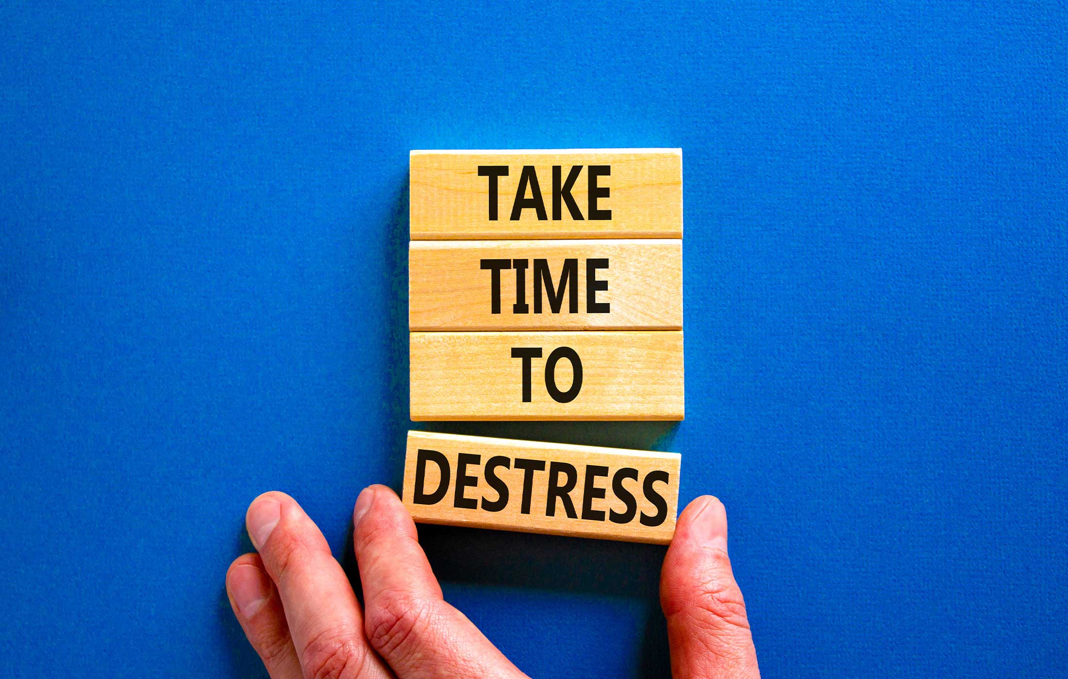 Wood blocks with the words "TAKE TIME TO DESTRESS" written on them