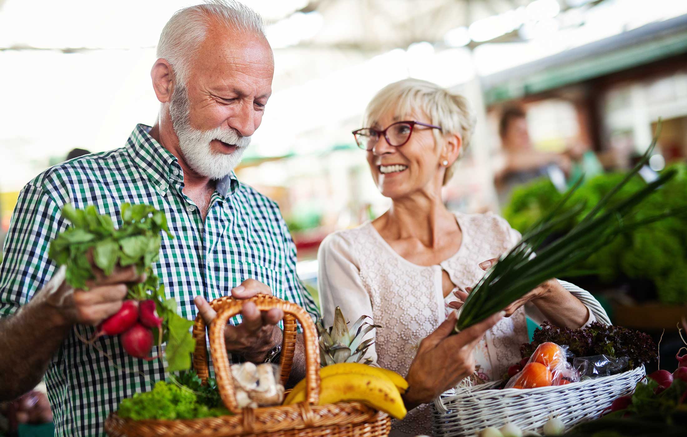 Elderly couple with wicker baskeds full of fresh produce